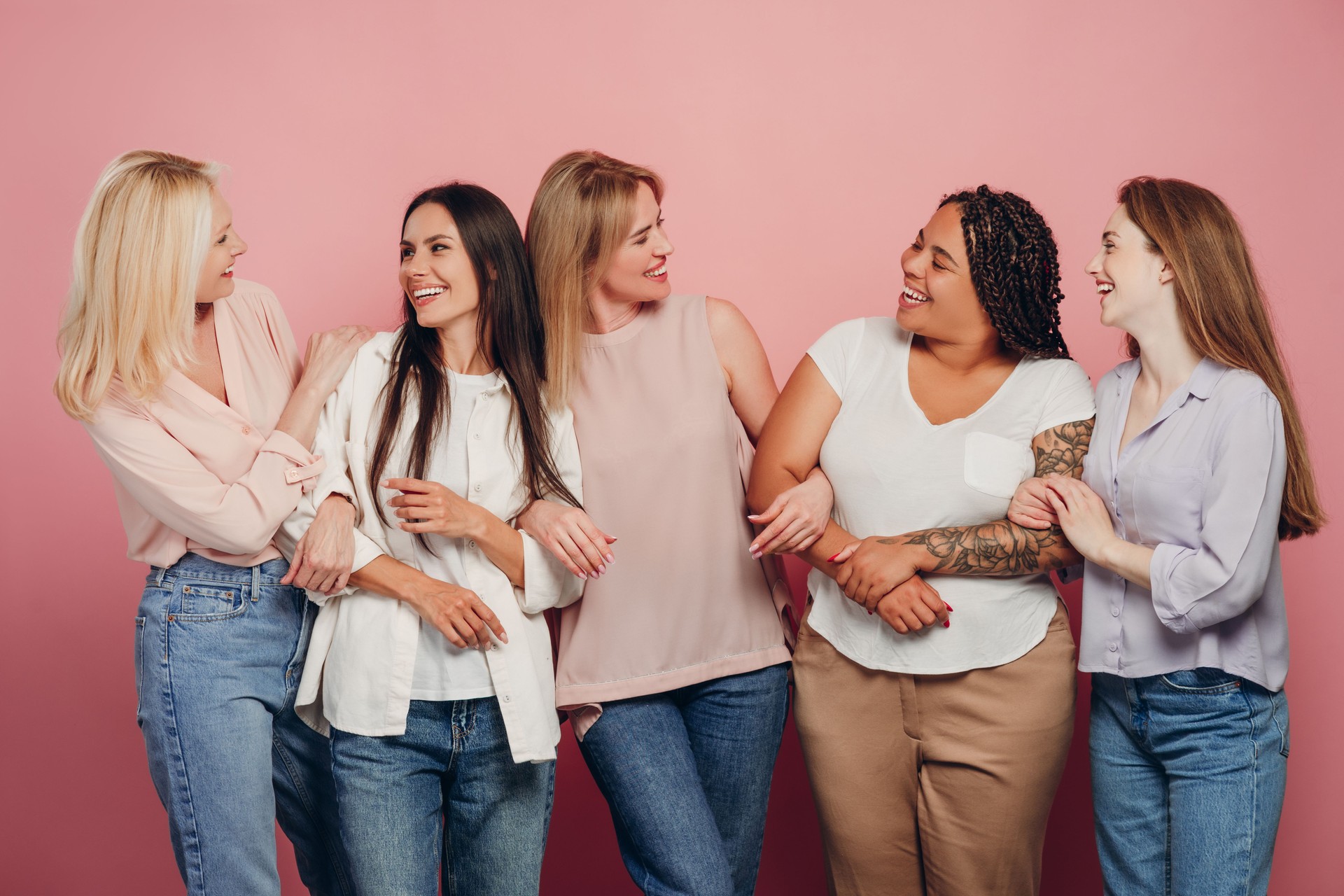 Five diverse women embracing each other, celebrating their friendship and diversity